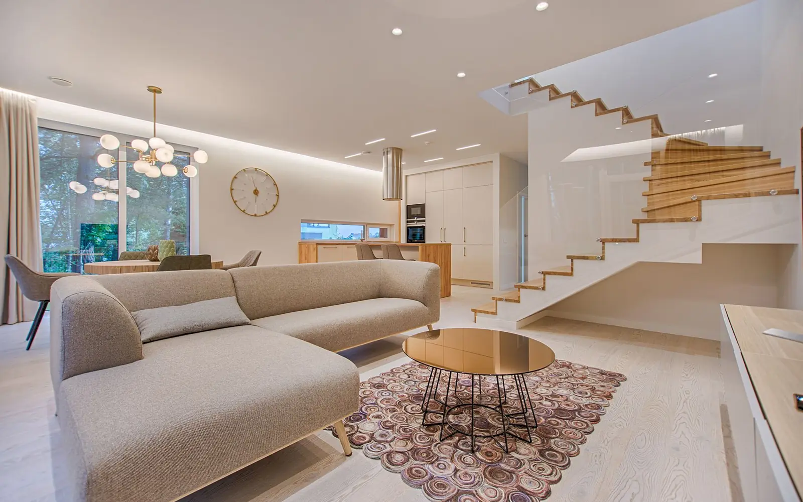 A bright contemporary living room and a poolside home at twilight