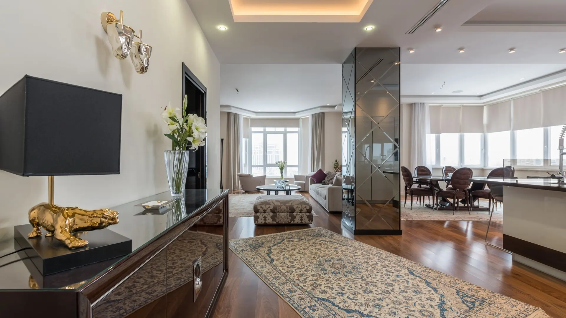 An elegant light-filled living room and a modern villa at sunset